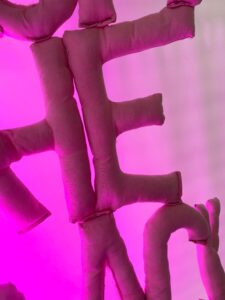 Letters made with pink fabric on light pink background