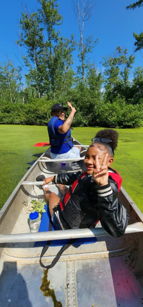 Two youths in a canoe looking back at camera